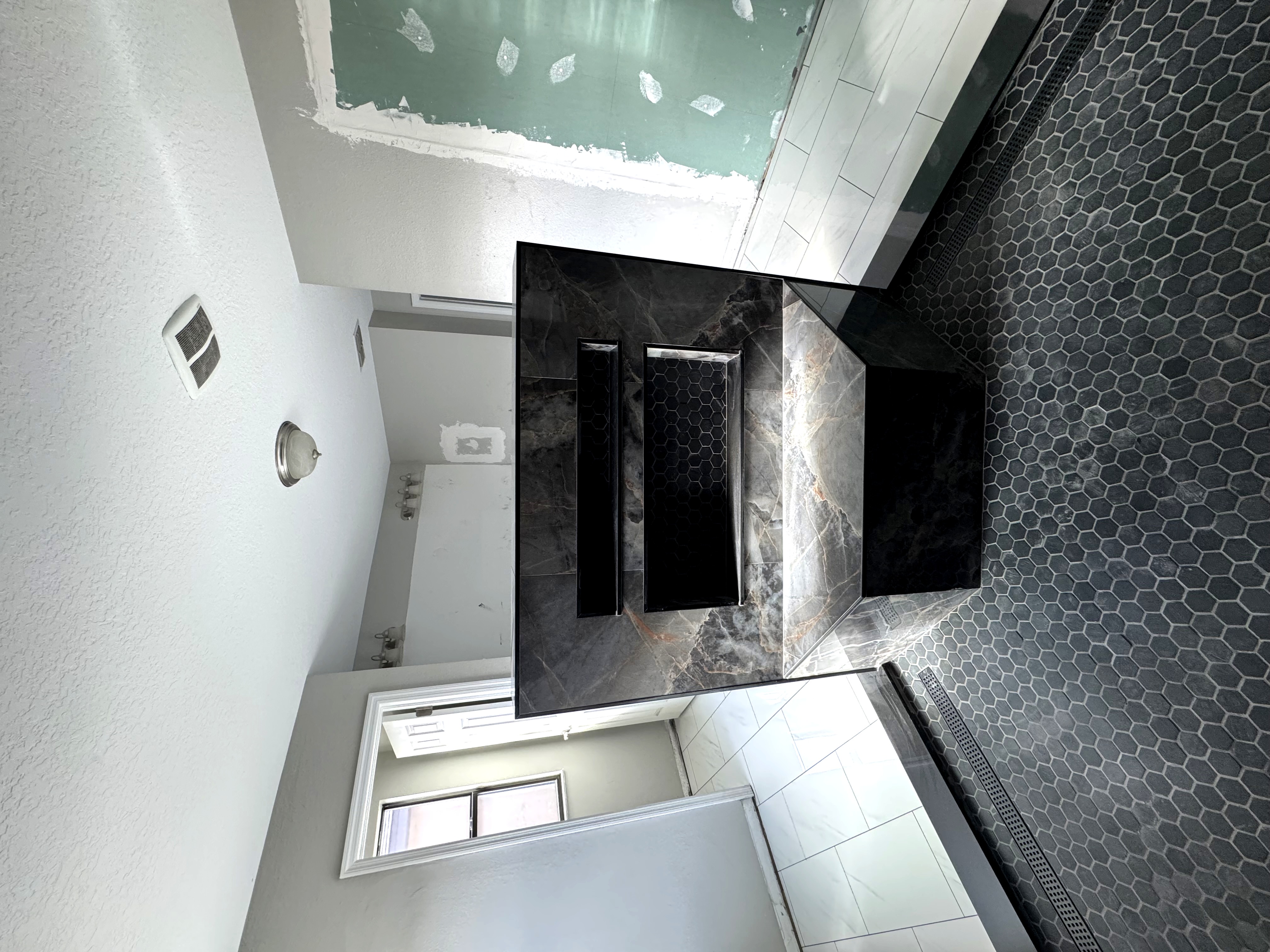 Bathroom mid-construction showing tile work in progress